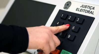 Mulher digita em urna eletrônica: mesmo com cotas, candidatas recebem menos que os homens em ele...